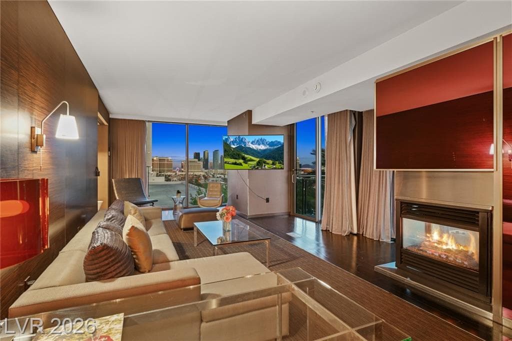 Furnished Palms Place condo living room at unit 8322 with fireplace, sectional sofa, and Las Vegas Strip view through floor-to-ceiling windows